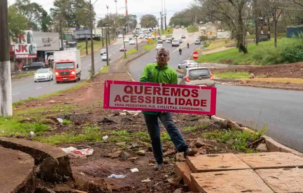 Em protesto por obra parada da JK, ciclista expõe faixa no viaduto em Foz do Iguaçu